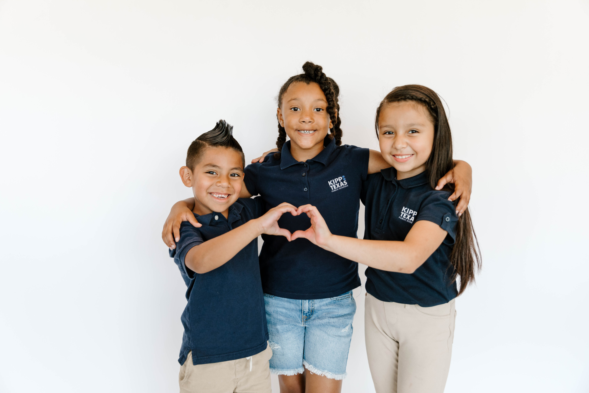 Three children making heart shape with hands