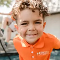 Young Child In Orange KIPP Texas Uniform Outside
