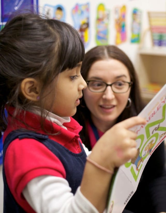 student looking at magazine with teacher