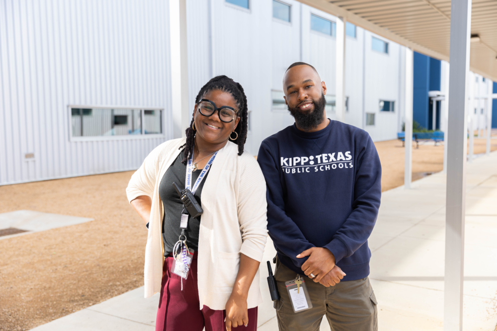 Two KIPP Texas staff members standing in front of a school building