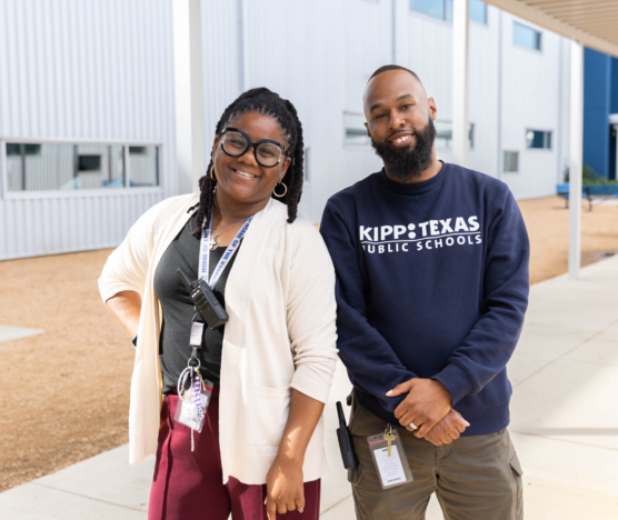 Two KIPP Texas staff members standing in front of a school building