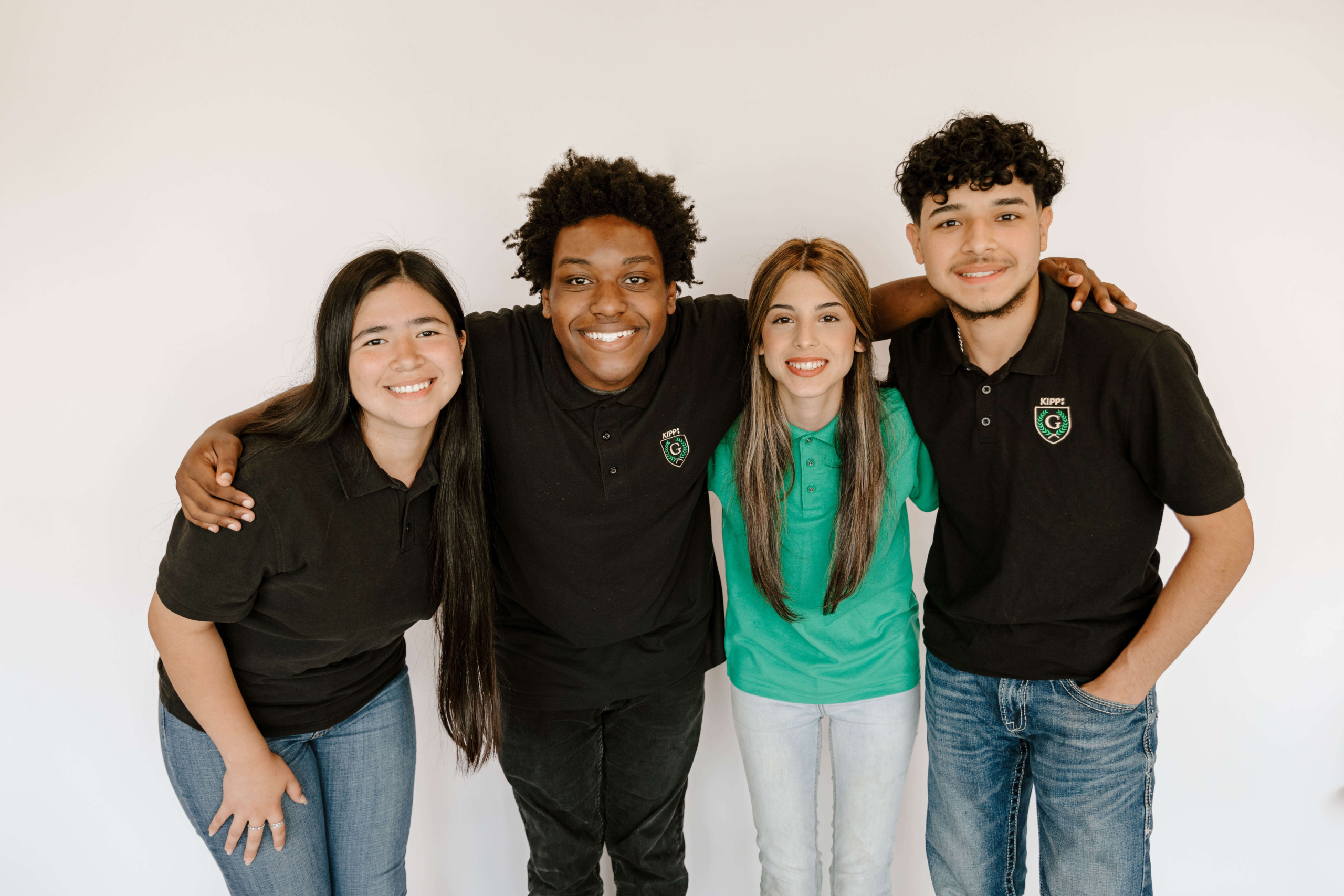 Cuatro estudiantes del último año de la escuela secundaria KIPP Texas - San Antonio sonriendo