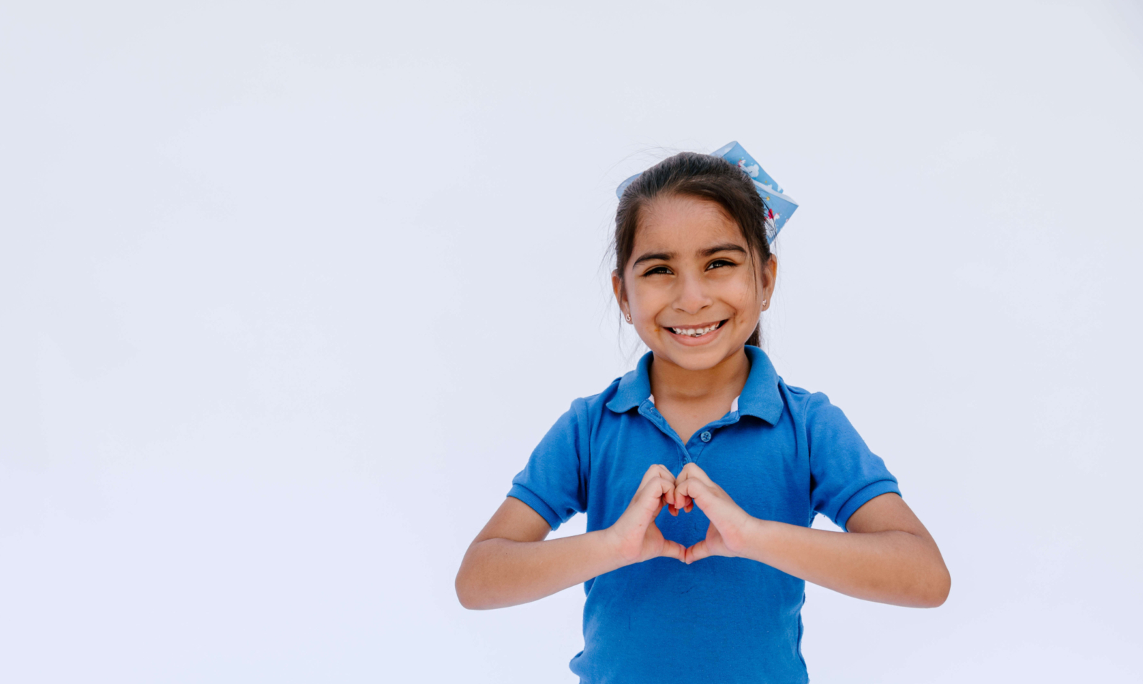 Estudiante de kindergarten de KIPP Texas - San Antonio con manos en forma de corazón