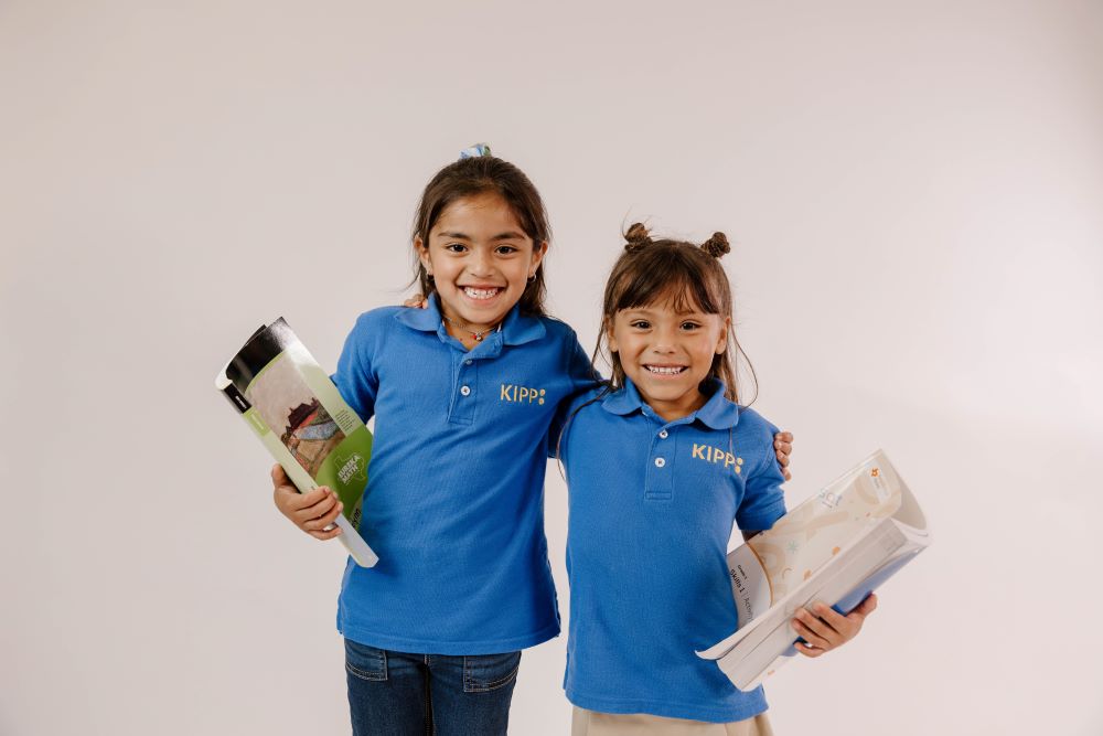 two-elementary-students-holding-books